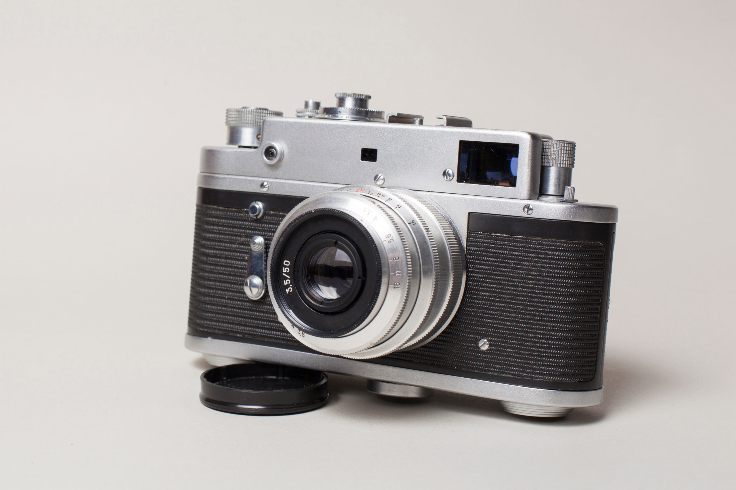An old fashioned camera sitting on top of a table with white background